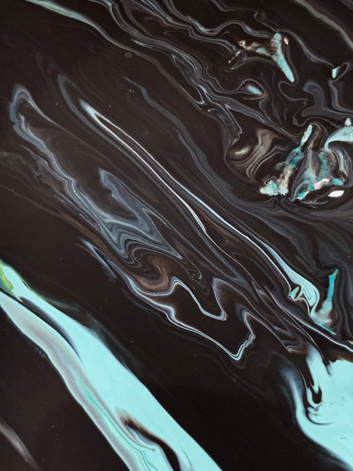 Abstract fluid art piece featuring dynamic swirls of black and blue with a glossy finish.